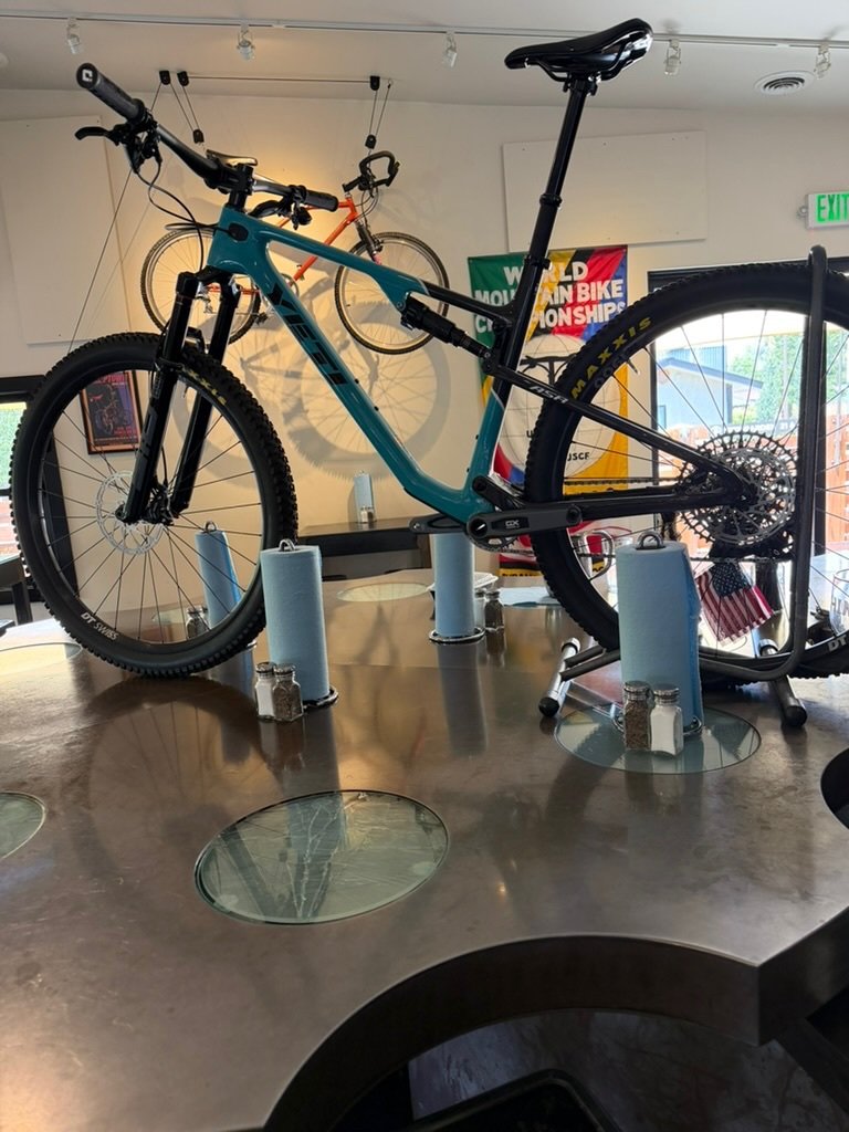 Teal mountain bike displayed on a table inside Power House